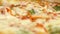 Close-up of juicy pizza with melted cheese. Stock footage. Middle of juicy mouth-watering pizzas with cuts in Italian