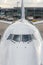 Close up of a jumbo jet nose, front view with windshield and wipers.