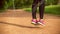 Close-up of jumping feet on the jump rope. Outdoor sports. Girl jumping on a skipping rope in park path with a green grass on back