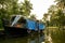 Close up of kerala houseboat in backwaters canal at sunset with warm light and palm trees, a relaxing scene