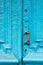 Close-up keyholes with curtains and a handle on the blue many times painted cracked double-barreled wooden vintage door