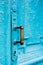 Close-up keyholes with curtains and a handle on the blue many times painted cracked double-barreled wooden vintage door