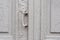 Close-up keyholes with curtains and a handle on the gray many times painted cracked double-barreled wooden vintage door