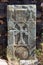 Close up of khachkar, covered with lichen, located on the bank of Sevan Lake, on cemetery of Hayravank Monastery, Armenia.