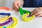 Close up of kid hands playing bright plastic toy constructor. Creative baby make new forms. copy space