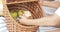 Close-up of kids hands taking a delicious bun from a basket during a picnic. Summer and weekend concept