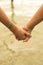 Close up of kids holding hands on beach concept