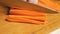 Close-up of a knife on a cutting board slicing carrots into sticks. Preparation of ingredients. Healthy and wholesome