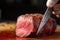 close-up of knife slicing through juicy piece of meat