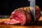 close-up of knife slicing through juicy piece of meat