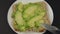 Close-up of a knife spreads a crumpled ripe soft avocado on a piece of cereal bread. Making a healthy avocado sandwich