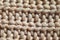 Close-up knit stitching beige close-up, handmade woolen fabric.