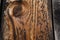 Close-up of a knothole in unfinished, raw, weathered wood