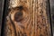 Close-up of a knothole in unfinished, raw, weathered wood