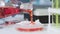 Close-up of lab researcher\'s hand pouring red liquid into glassware, cosmetology