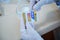 Close-up lab technician& x27;s hands in medical gloves, holding a litmus or reagent paper, conducting PH test in medical