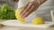 Close-up lady hands cutting yellow lemons, making fresh lemonade, cooking