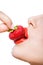 Close up of lady\'s mouth eating strawberry