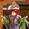 Close-up of Lama in ritual costume and ornate hat performs a historical mystery Black Hat Dance of Tibetan Buddhism on the Cham
