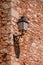 Close-up of lamp stuck in stone wall in sunny day, in Roussillon.