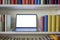 Close up of laptop in bookcase with colorful books