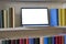 Close up of laptop in a colorful bookshelf