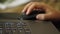 Close-up of the laptop keyboard. In the background, a woman`s hand with a computer mouse is out of focus. The concept of remote wo