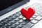 Close up of laptop with a red heart on the keyboard.Online dating concept