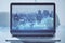 Close up of laptop screen with abstract glowing blue business graph on blurry city background. Financial growth, market and stock