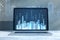 Close up of laptop screen at workpkace with abstract glowing city skyline hologram on blurry background. Metaverse, innovation and