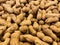 Close up of a large pile of unpeeled peanuts in the skin. Nuts natural background