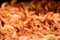 Close up of large portion of cooked shrimps with tomato sauce and yellow lemons in a large pan at a street food festival, ready to