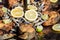 Close up of large portion of fried fish decorated with yellow lemons slices in a large pan at a street food festival, ready to eat