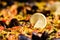 Close up of large portion of traditional Spanish paella dish freshly being cooked with seafood and rice in a frying pan at a stree