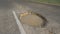 CLOSE UP: Large pothole in the middle of the road is filled with murky water.