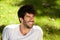 Close up laughing handsome man with beard sitting in grass