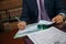 Close up of lawyer businessman sitting at table and signing document