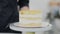 Close-up of layer cake rolling with unrecognizable Caucasian man standing at background. Delicious sweet pastry in