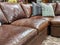 Close up of a leather sectional covered with pillows