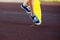 Close up legs in blue sneakers riding on yellow skateboard in motion. Active urban lifestyle of youth, training, hobby, activity