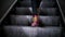 Close-up of legs in boots taking steps on the steps of an escalator.