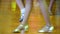 Close-up of legs dancing couples in ballroom.