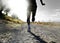 Close up legs and feet of extreme cross country man running and training on rural track jogging at sunset