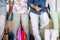 Close up of legs of four people after shopping with shopping bags on the ground - family go buying clothes or doing gifts