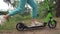 A close-up of the legs of a girl riding a scooter Happy family walks in the park