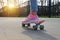 Close-up legs girl skateboarder blue jeans and pink sneakers riding pink penny skate longboard. Concept of sports and development