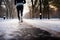 Close-up at legs of a male runner jogging in a park cover by snow.