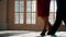 Close-up of the legs of a man and a woman dancing a pair of ballroom dance in the room. Dance moves of the tango.