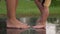 Close Up Legs Of Playful Baby And Mother Barefoot Stomping On Puddle On Asphalt