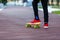 Close up legs in red sneakers riding on yellow skateboard in motion. Active urban lifestyle of youth, training, hobby,